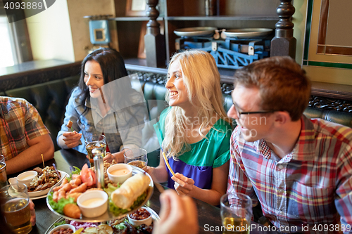 Image of friends dining and drinking beer at restaurant