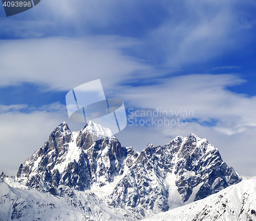 Image of Mounts Ushba and Chatyn and blue sky with clouds in winter wind 