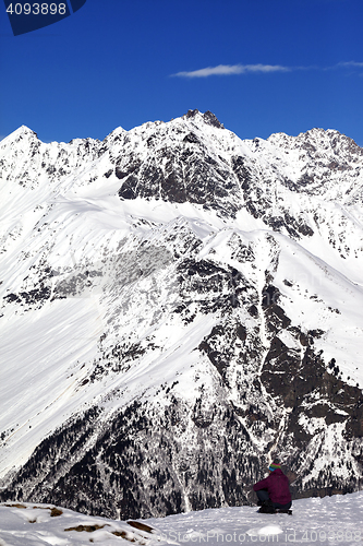 Image of Woman resting on slope in winter snow mountain at sun day