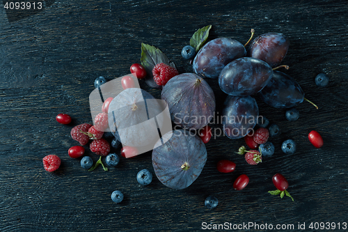 Image of ripe figs and berries with a bunch of basil