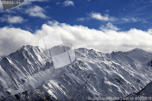 Image of Snow winter mountains and cloud sky in sun evening