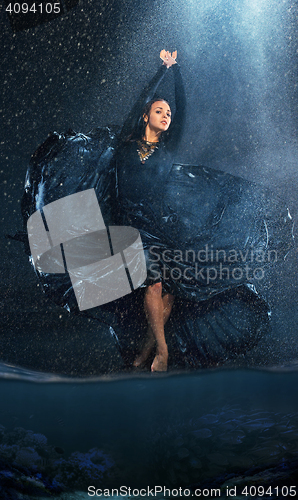 Image of The young beautiful modern dancer dancing under water drops