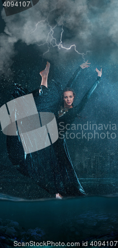 Image of The young beautiful modern dancer dancing under water drops