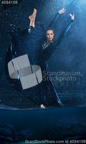 Image of The young beautiful modern dancer dancing under water drops