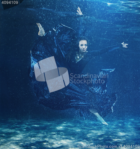 Image of The young beautiful modern dancer dancing under water drops