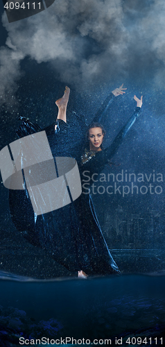 Image of The young beautiful modern dancer dancing under water drops