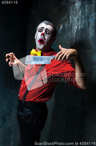 Image of The crazy clown holding a knife on dack. Halloween concept