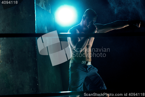 Image of Male boxer boxing in a dark studio