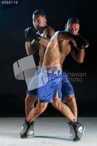 Image of Male boxer boxing in a dark studio