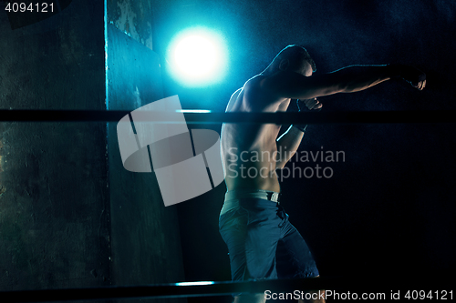 Image of Male boxer boxing in a dark studio