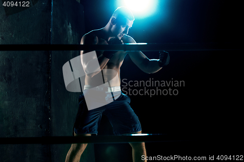 Image of Male boxer boxing in a dark studio