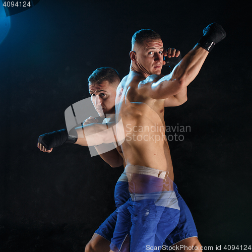 Image of Male boxer boxing in a dark studio