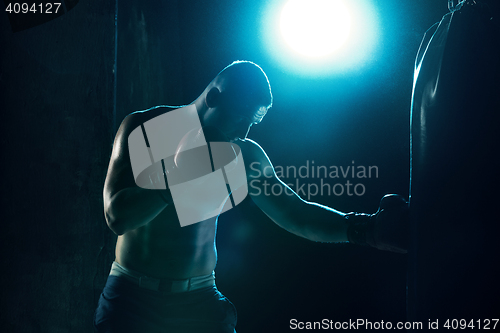 Image of Male boxer boxing in punching bag