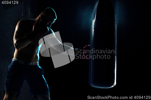 Image of Male boxer boxing in punching bag