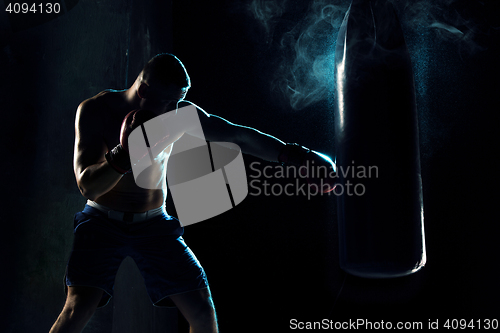 Image of Male boxer boxing in punching bag