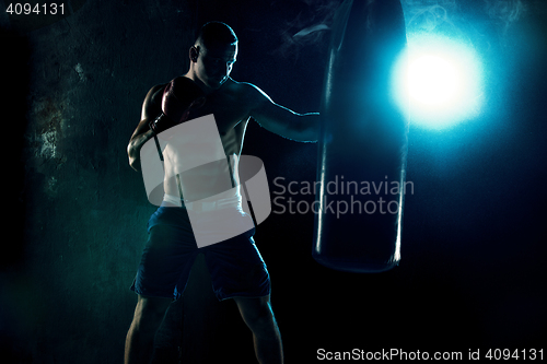 Image of Male boxer boxing in punching bag