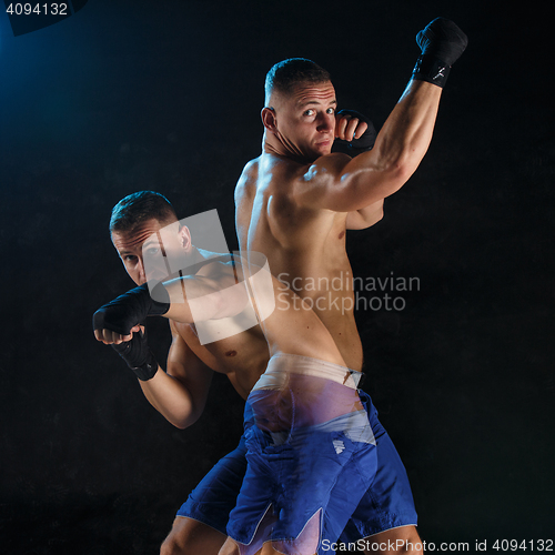 Image of Male boxer boxing in a dark studio