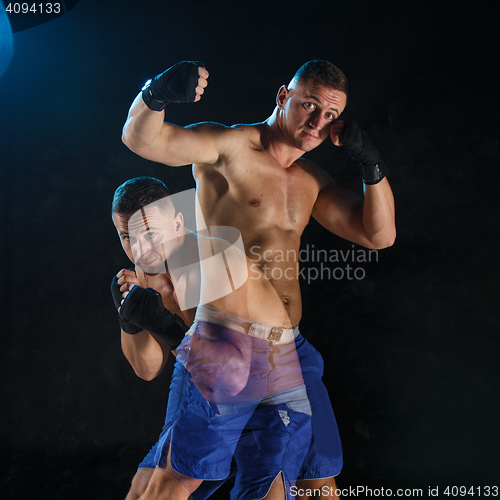 Image of Male boxer boxing in a dark studio