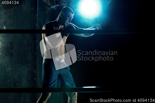 Image of Male boxer boxing in a dark studio