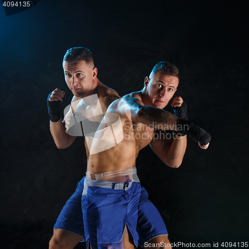 Image of Male boxer boxing in a dark studio