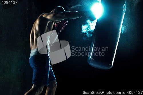 Image of Male boxer boxing in punching bag