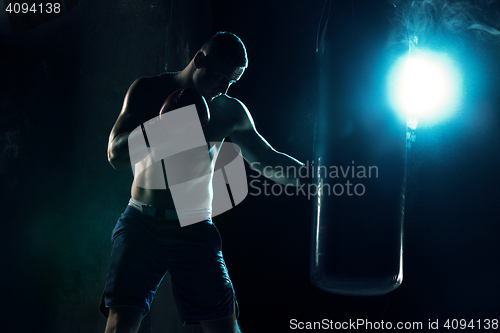 Image of Male boxer boxing in punching bag