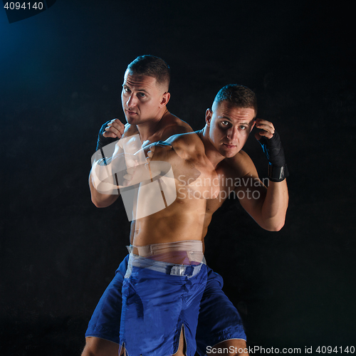 Image of Male boxer boxing in a dark studio