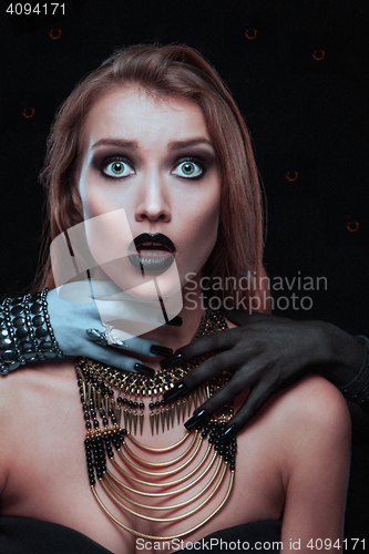 Image of Pretty gothic woman with hands of vampire on her neck