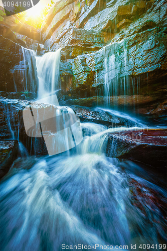 Image of Tropical waterfall with sun rays