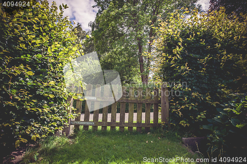 Image of Wooden gate in a green garden