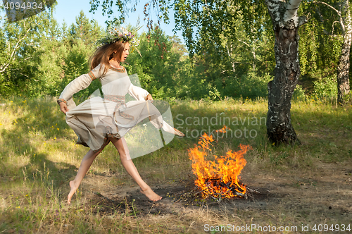 Image of Attractive girl jump through fire