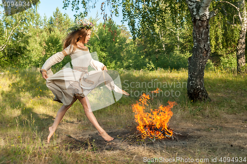 Image of Attractive girl jump through fire