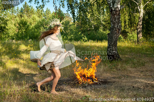 Image of Attractive girl jump through fire