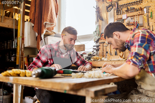 Image of carpenters with ruler and blueprint at workshop