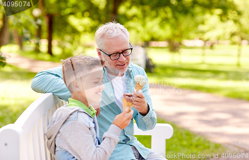 Image of old man and boy eating ice cream at summer park