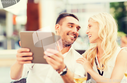 Image of happy couple with tablet pc at restaurant lounge