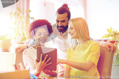 Image of happy creative team with tablet pc in office