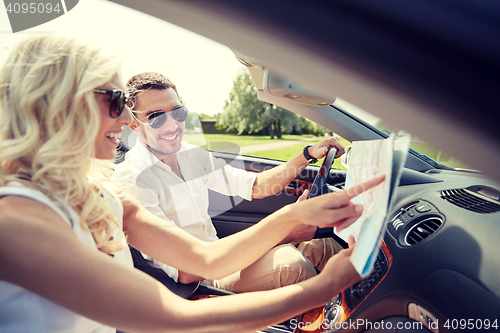 Image of happy man and woman with map in cabriolet car