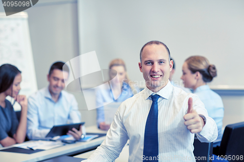 Image of group of smiling businesspeople meeting in office