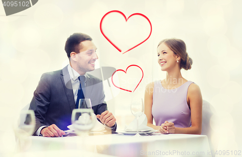 Image of smiling couple looking at each other at restaurant