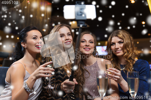 Image of women with smartphone taking selfie at night club