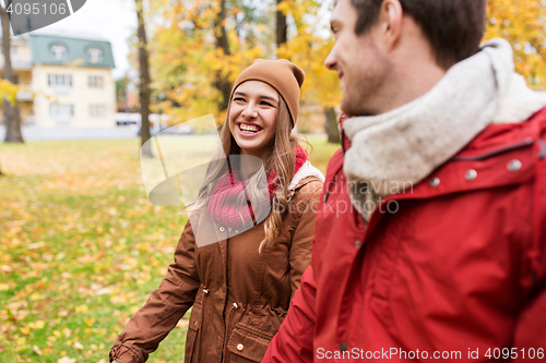 Image of happy young couple walking in autumn park