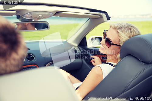 Image of happy man and woman driving in cabriolet car