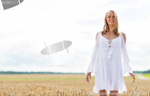 Image of smiling young woman in white dress on cereal field