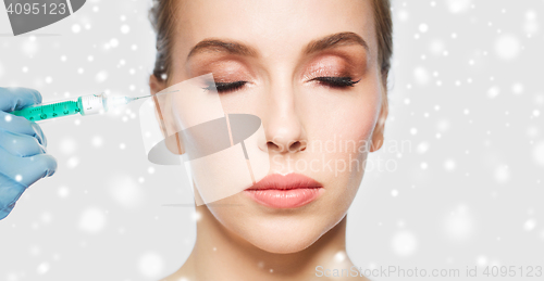 Image of close up of woman face and hand with syringe