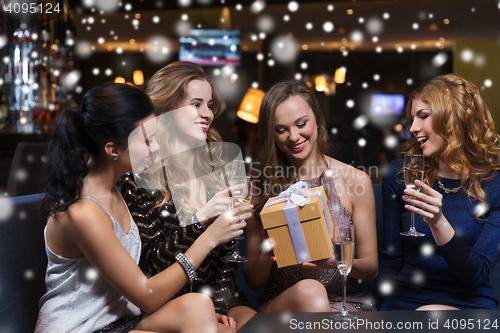 Image of happy women with champagne and gift at night club