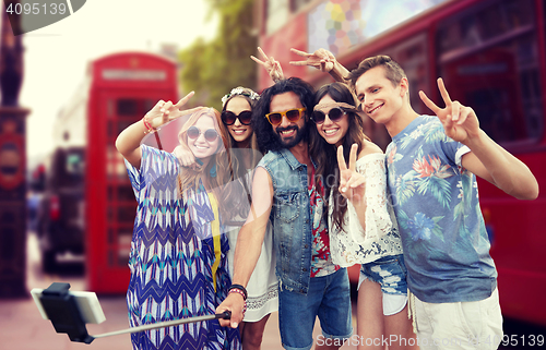 Image of hippie friends with smartphone on selfie stick