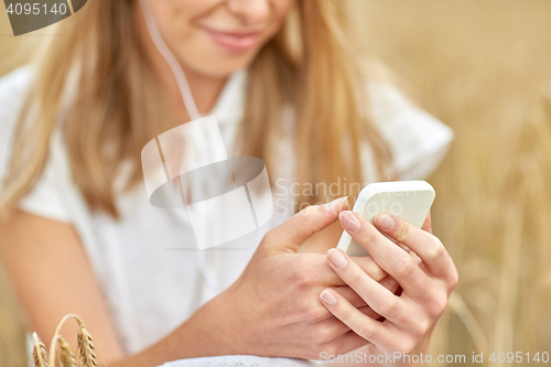 Image of close up of woman with smartphone and earphones