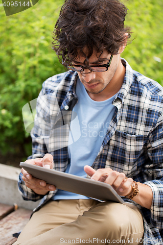 Image of man in glasses with tablet pc computer outdoors