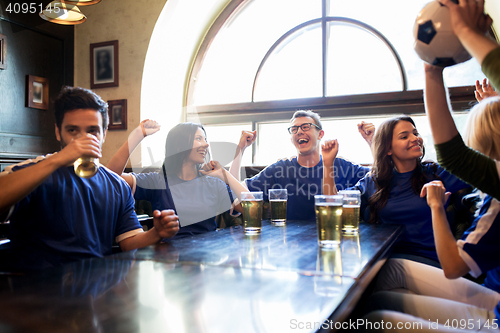 Image of football fans or friends with beer at sport bar